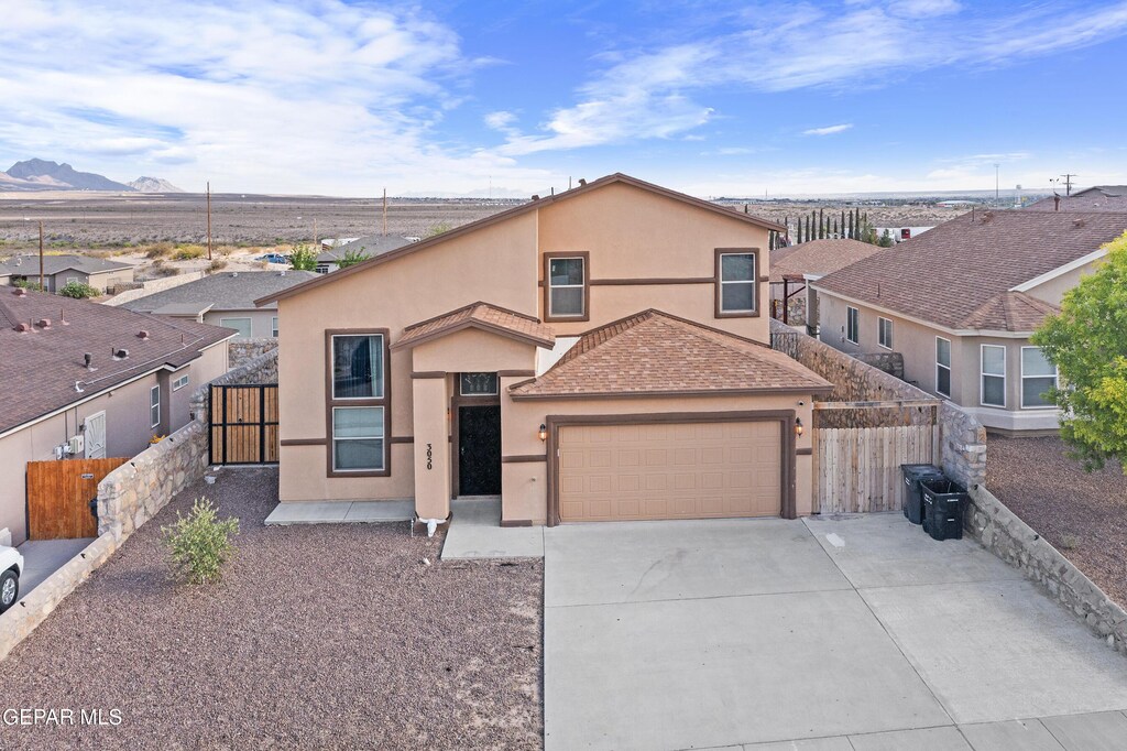 3050 Selene Vega Ave, Anthony, TX 79821 - view of front of house with stucco siding, fence, driveway, a garage, and a mountain view