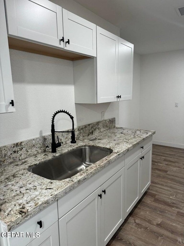 3512 Kemp Ave, El Paso, TX 79904 - kitchen with white cabinetry, dark wood-style flooring, and light stone counters