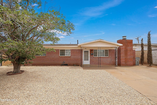 view of front of house with concrete driveway, brick siding, and fence