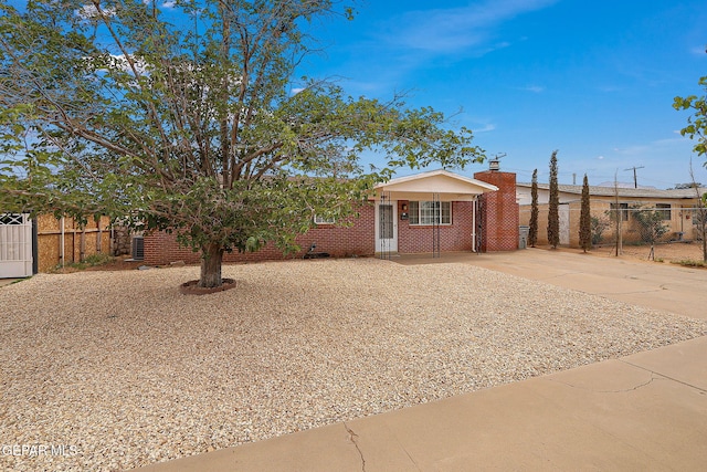 view of front of property featuring fence, a chimney, and driveway