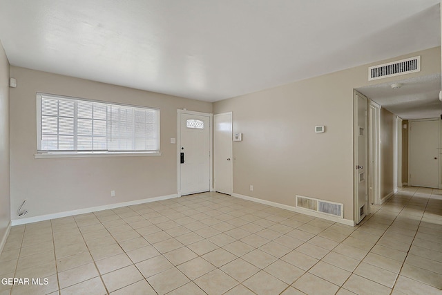 entryway with baseboards and light tile patterned floors