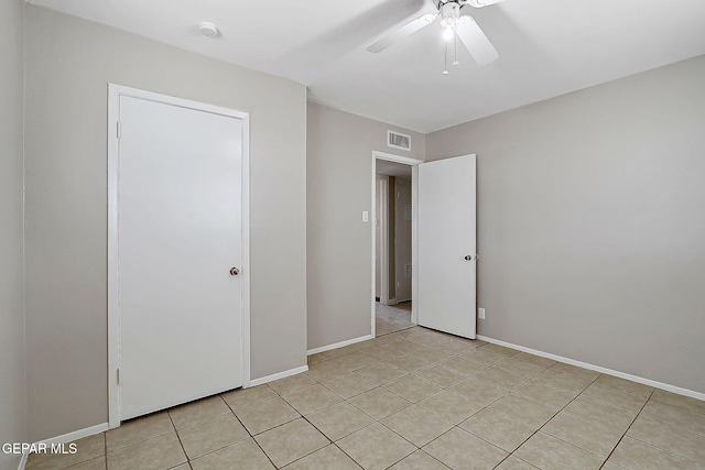 unfurnished bedroom featuring light tile patterned floors, baseboards, and a ceiling fan