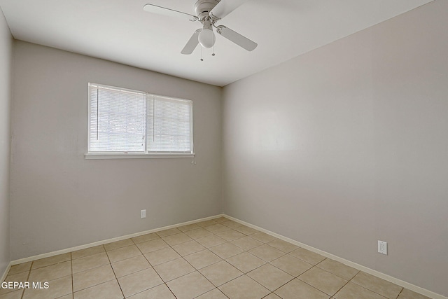 spare room with light tile patterned floors, baseboards, and a ceiling fan