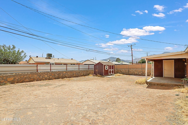 fenced backyard featuring a shed and an outdoor structure