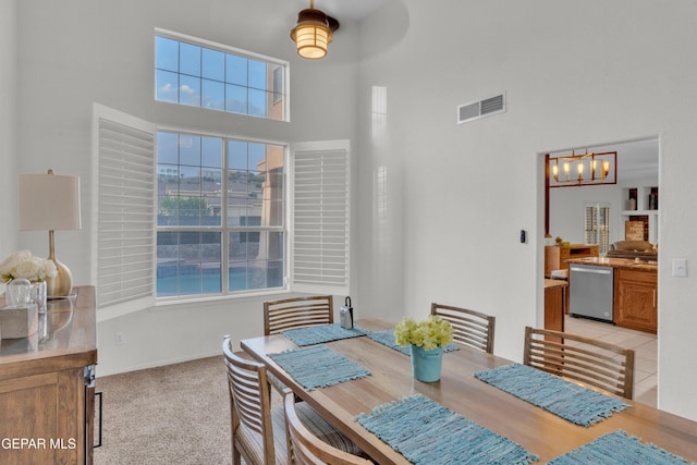 dining area featuring a high ceiling, a chandelier, and baseboards