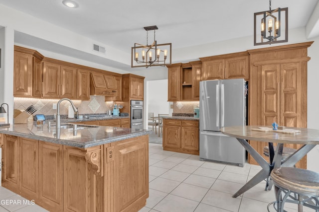kitchen featuring stainless steel appliances, a chandelier, a sink, custom exhaust hood, and a peninsula