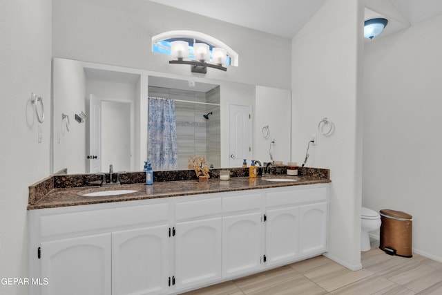 full bath featuring a tile shower, toilet, baseboards, a chandelier, and double vanity