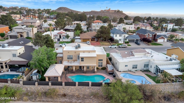 aerial perspective of suburban area with a pool and a mountainous background