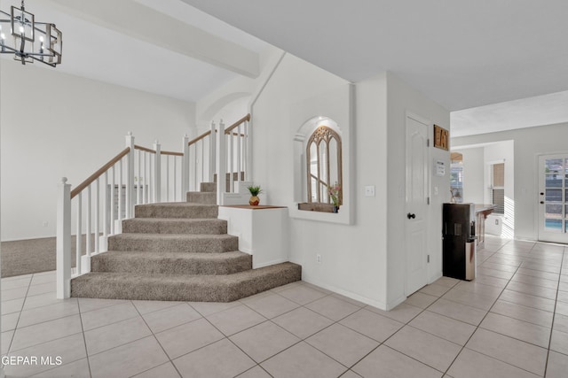 staircase with tile patterned flooring, a chandelier, and baseboards