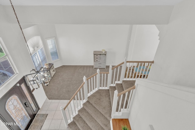stairway with carpet and tile patterned flooring