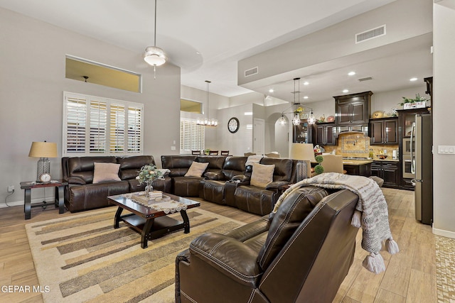 12289 Fresh Water Dr, El Paso, TX 79928 - living room featuring light wood finished floors, arched walkways, a chandelier, baseboards, and recessed lighting