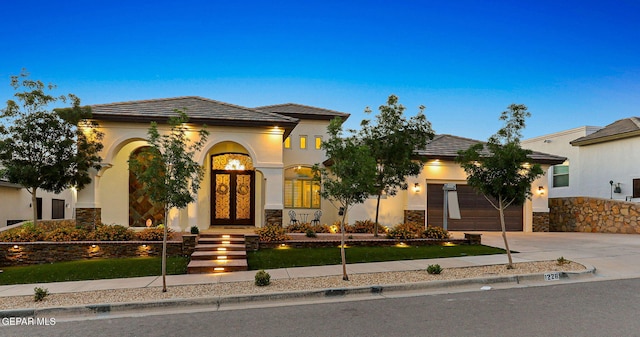 12289 Fresh Water Dr, El Paso, TX 79928 - mediterranean / spanish home with concrete driveway, an attached garage, stucco siding, french doors, and stone siding