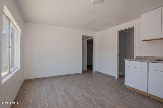 318 Austin St, Fabens, TX 79838 - unfurnished living room featuring plenty of natural light, wood finished floors, and baseboards