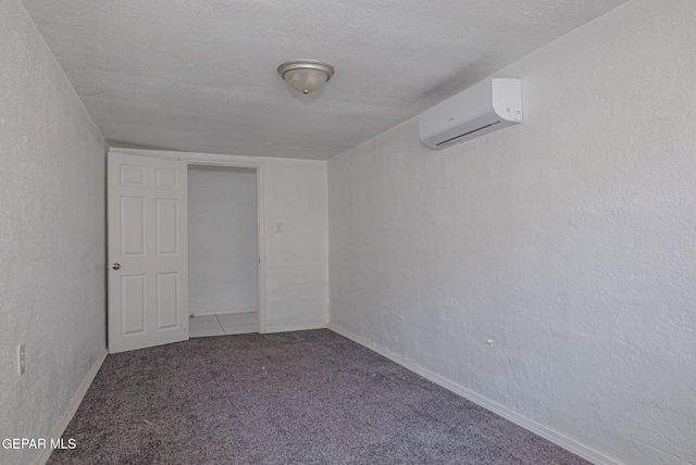 318 Austin St, Fabens, TX 79838 - spare room with an AC wall unit, carpet flooring, a textured ceiling, and baseboards