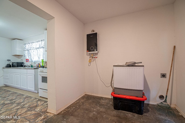 318 Austin St, Fabens, TX 79838 - miscellaneous room featuring water heater, baseboards, and unfinished concrete floors