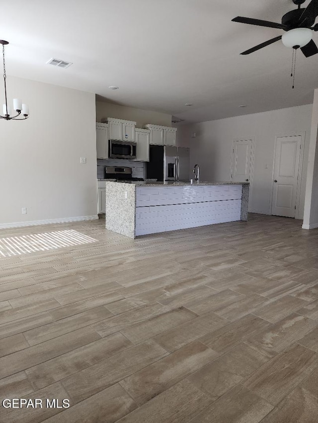 14508 Russell Borea, El Paso, TX 79938 - kitchen with appliances with stainless steel finishes, a sink, white cabinetry, a kitchen island with sink, and a ceiling fan