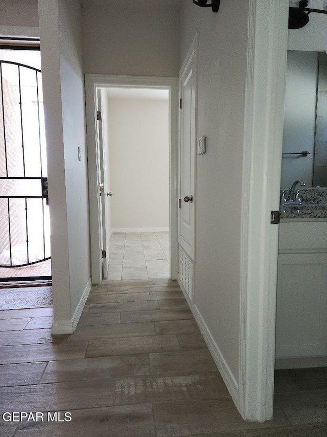 14508 Russell Borea, El Paso, TX 79938 - hallway featuring wood finished floors, healthy amount of natural light, a sink, and baseboards