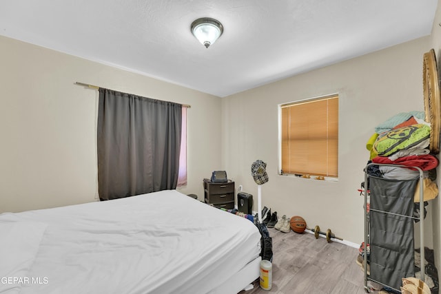 bedroom with wood finished floors and baseboards
