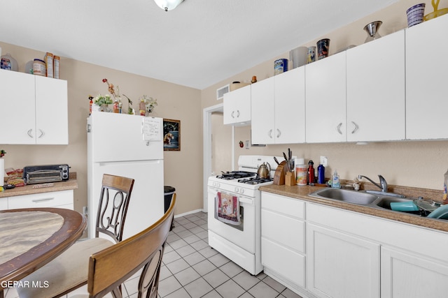 kitchen with white appliances, a sink, white cabinetry, and light countertops