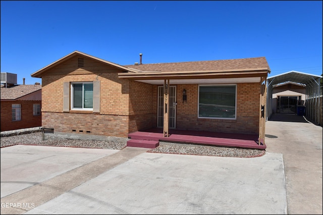 ranch-style home with a carport, brick siding, cooling unit, and a porch
