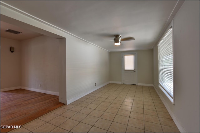 unfurnished room featuring a ceiling fan, light tile patterned floors, and baseboards