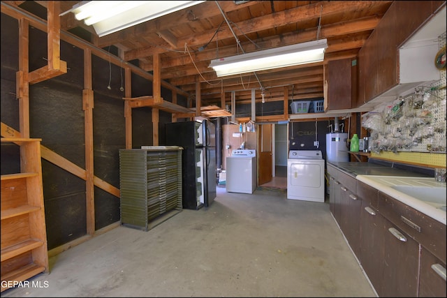 below grade area featuring gas water heater, washer and dryer, and freestanding refrigerator