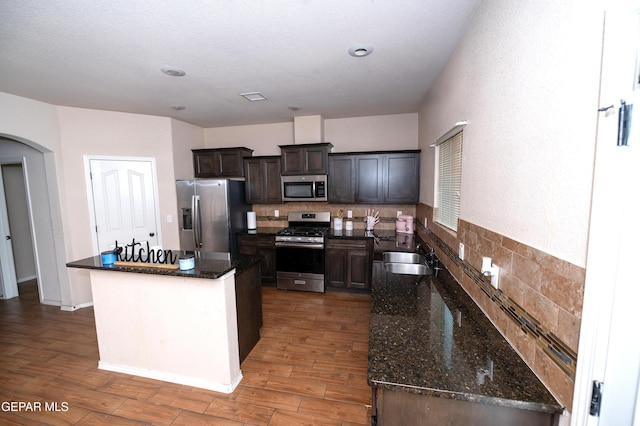 804 Spofforth Rd, El Paso, TX 79928 - kitchen featuring stainless steel appliances, a sink, arched walkways, and backsplash