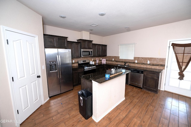 804 Spofforth Rd, El Paso, TX 79928 - kitchen featuring appliances with stainless steel finishes, a sink, dark wood finished floors, a center island, and dark stone countertops