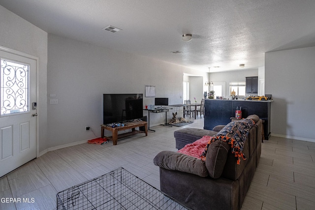 living area with baseboards and a textured ceiling