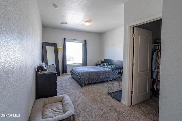 bedroom featuring carpet, a textured wall, and a textured ceiling
