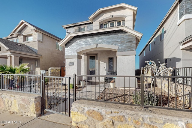 14813 Pebble Hills Blvd, El Paso, TX 79938 - view of front of house with stone siding, a fenced front yard, stucco siding, and a gate