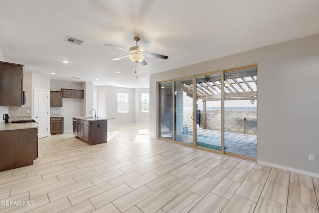 14813 Pebble Hills Blvd, El Paso, TX 79938 - kitchen featuring a sink, open floor plan, light countertops, ceiling fan, and dark brown cabinetry
