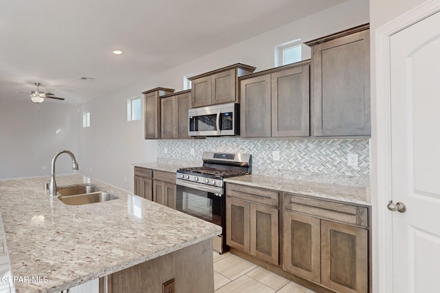 14813 Pebble Hills Blvd, El Paso, TX 79938 - kitchen with stainless steel appliances, a sink, tasteful backsplash, a ceiling fan, and light stone counters