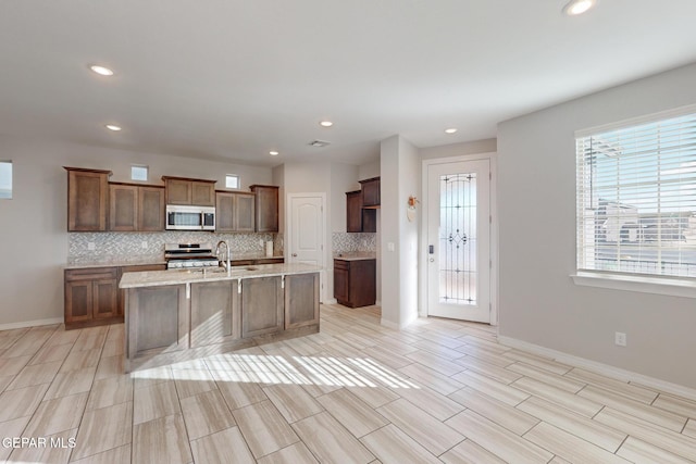 14813 Pebble Hills Blvd, El Paso, TX 79938 - kitchen with stainless steel appliances, backsplash, recessed lighting, a center island with sink, and wood tiled floors