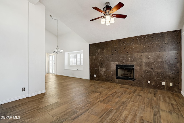 3400 Buffalo Soldier Cir, El Paso, TX 79936 - unfurnished living room featuring high vaulted ceiling, a chandelier, a ceiling fan, wood finished floors, and a tiled fireplace