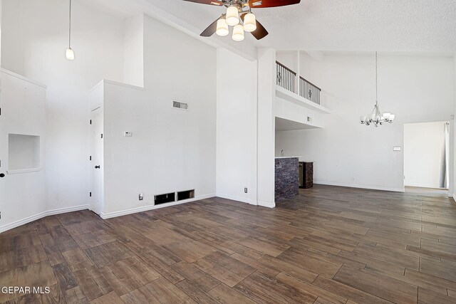 3400 Buffalo Soldier Cir, El Paso, TX 79936 - unfurnished living room with high vaulted ceiling, ceiling fan, a chandelier, wood finished floors, and baseboards