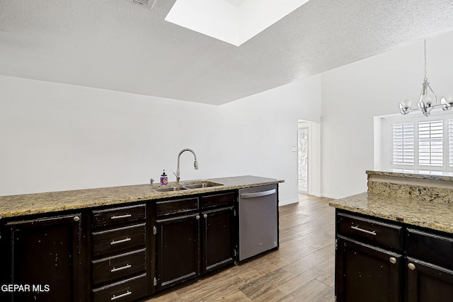 3400 Buffalo Soldier Cir, El Paso, TX 79936 - kitchen with dishwasher, a sink, a chandelier, light wood finished floors, and a textured ceiling