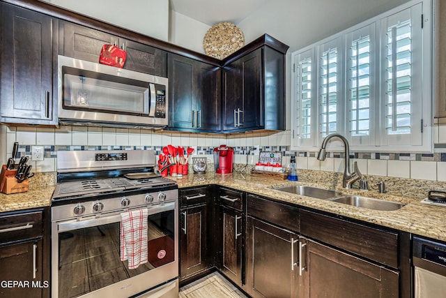 14837 Tierra Crystal Ave, El Paso, TX 79938 - kitchen with appliances with stainless steel finishes, a sink, light stone counters, dark brown cabinets, and tasteful backsplash