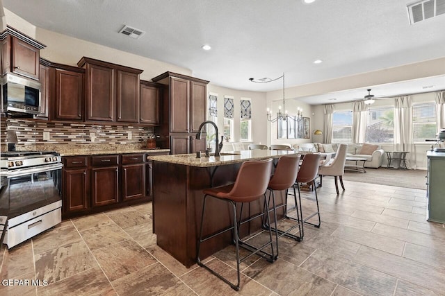 5525 Valley Cedar Dr, El Paso, TX 79932 - kitchen featuring stainless steel appliances, light stone countertops, backsplash, open floor plan, and recessed lighting
