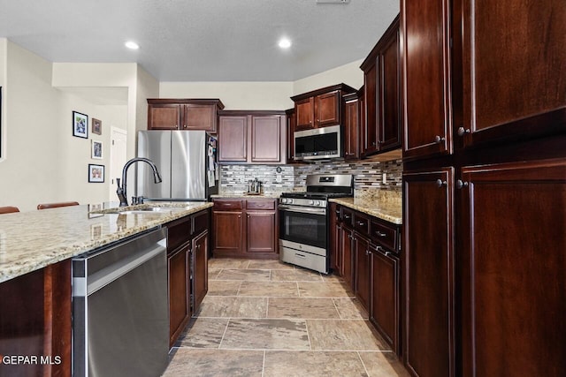 5525 Valley Cedar Dr, El Paso, TX 79932 - kitchen with appliances with stainless steel finishes, a sink, decorative backsplash, light stone countertops, and recessed lighting