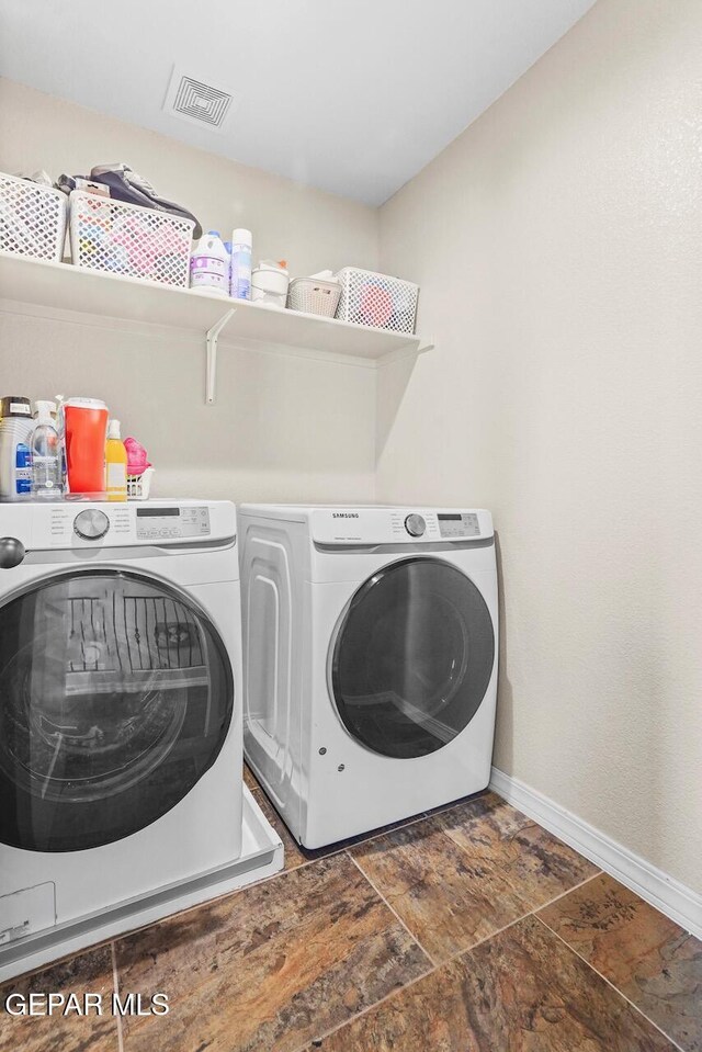 5525 Valley Cedar Dr, El Paso, TX 79932 - laundry room featuring washer and clothes dryer, baseboards, and stone finish flooring