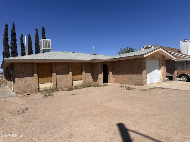 9836 Isaac Dr, El Paso, TX 79927 - view of front of home featuring brick siding, a garage, concrete driveway, and central AC