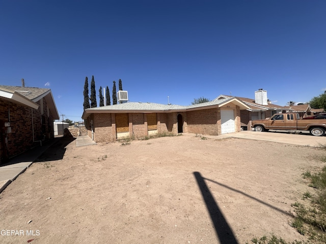 9836 Isaac Dr, El Paso, TX 79927 - rear view of property featuring an attached garage, concrete driveway, and brick siding
