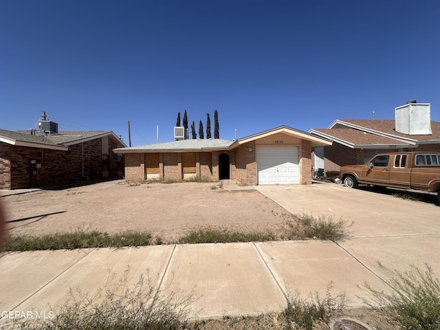 9836 Isaac Dr, El Paso, TX 79927 - view of front of home featuring an attached garage, concrete driveway, brick siding, and central air condition unit