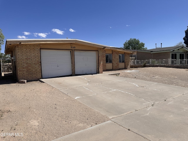 8149 Tranquilo Dr, El Paso, TX 79907 - view of front of property featuring brick siding, a garage, and driveway
