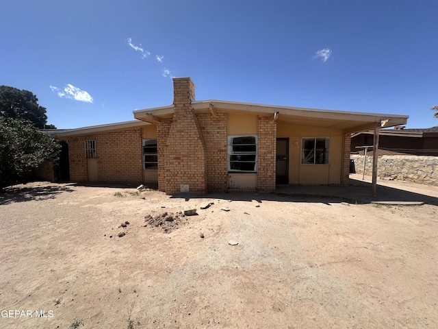 8149 Tranquilo Dr, El Paso, TX 79907 - rear view of property with a chimney and brick siding