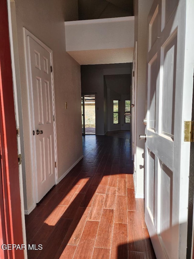 corridor with wood finished floors and baseboards