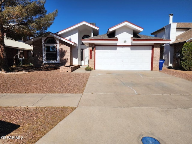single story home with a garage, driveway, and brick siding