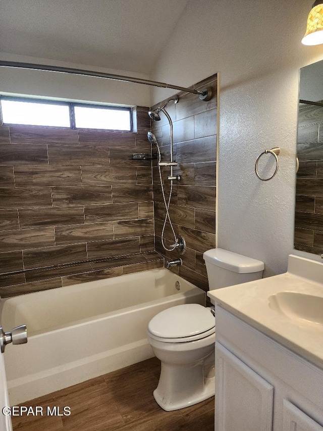 full bathroom featuring toilet, bathtub / shower combination, vanity, wood finished floors, and a textured wall