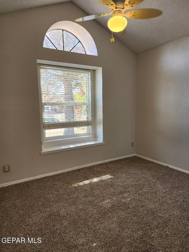 empty room featuring lofted ceiling, a textured ceiling, a ceiling fan, carpet flooring, and baseboards